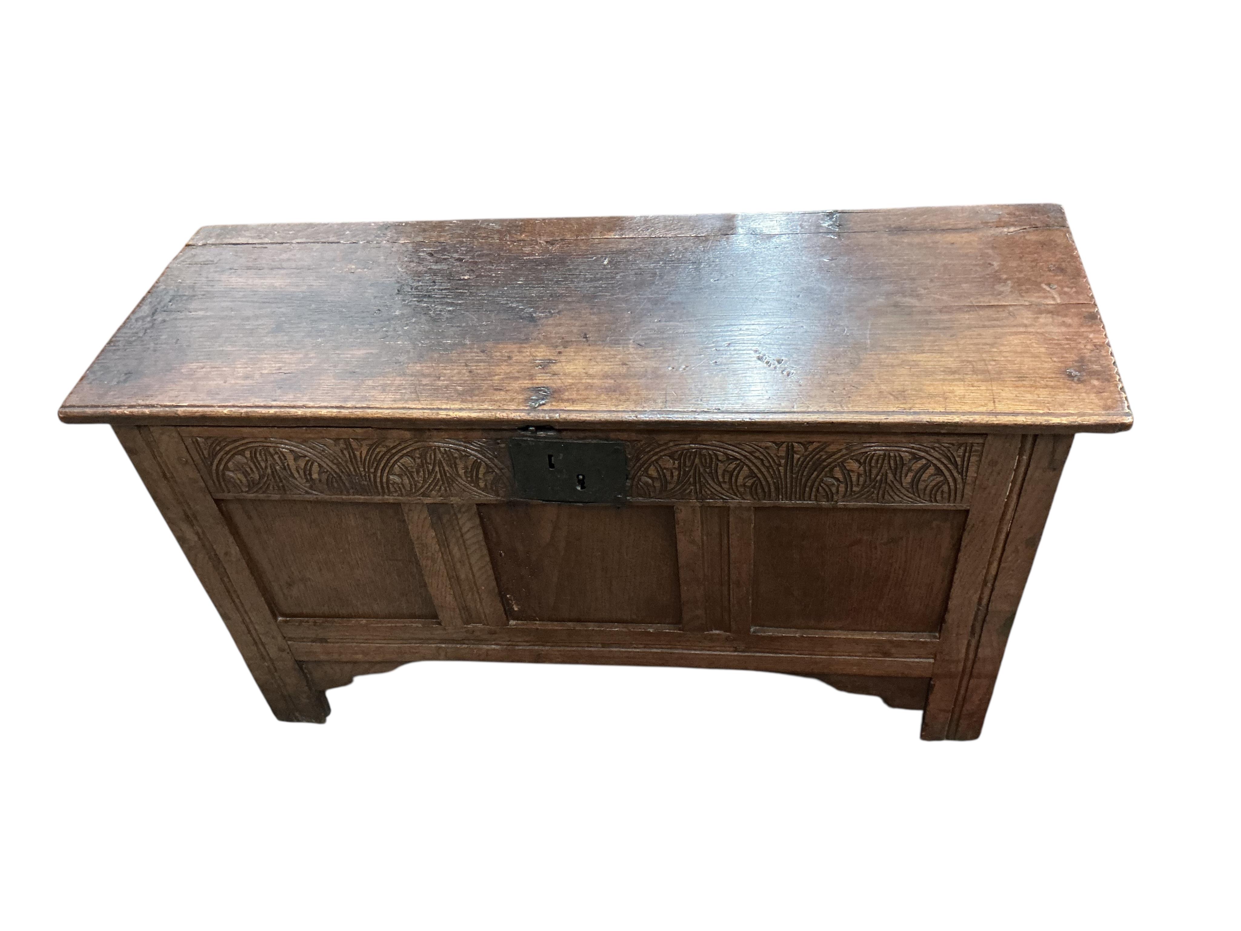 A small 17th century oak chipped carved coffer, width 104cm, depth 36cm, height 57cm
